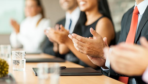 Business people applauding in meeting.